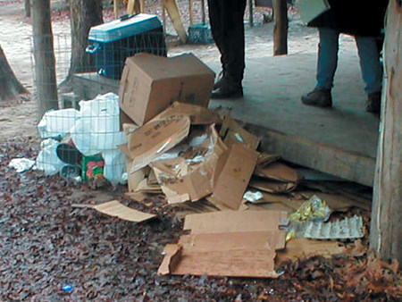 Food preparation area at a therapeutic campsite, littered with trash